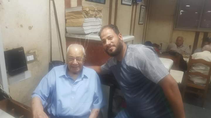 " أيمن حسني" أحد العاملين بالمطعم في صورة تذكاريه له مع محمد أحمد
